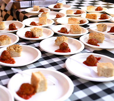 table of plates containing meatballs and rosemary bread