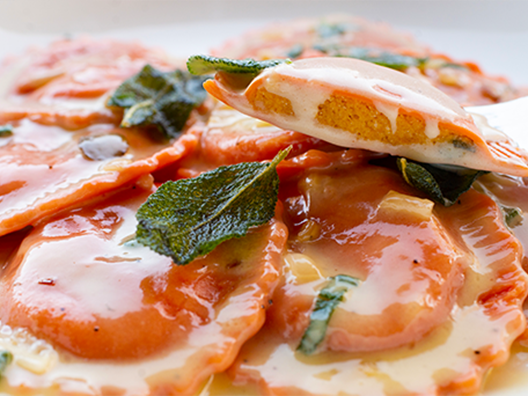 close up image of pumpkin ravioli cut in half showing creamy interior