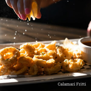 fried calamari with hand squeezing lemon