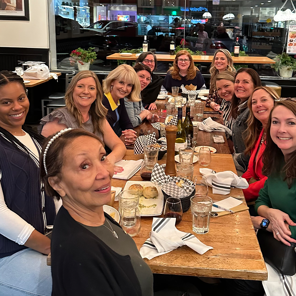 gathering of women sitting around the table smiling