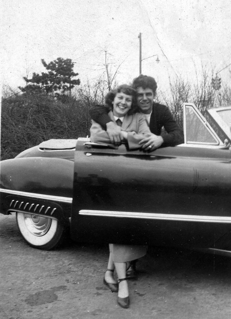 A young Maria and Donald next to their car