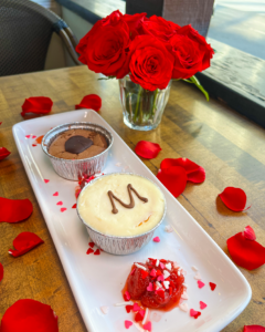 Dessert plate next to a vase of red roses