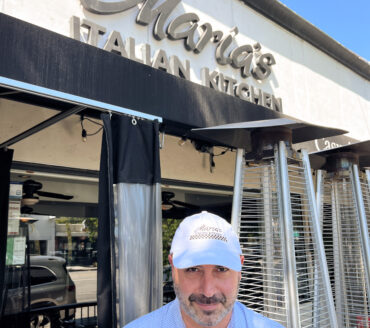 A man in a Maria's dad cap standing in front of Maria's